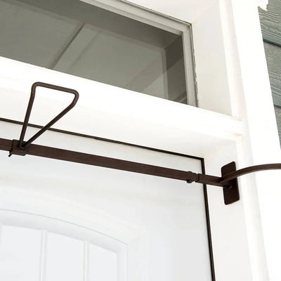 Metal awning bracket attached to a white door with a neutral background