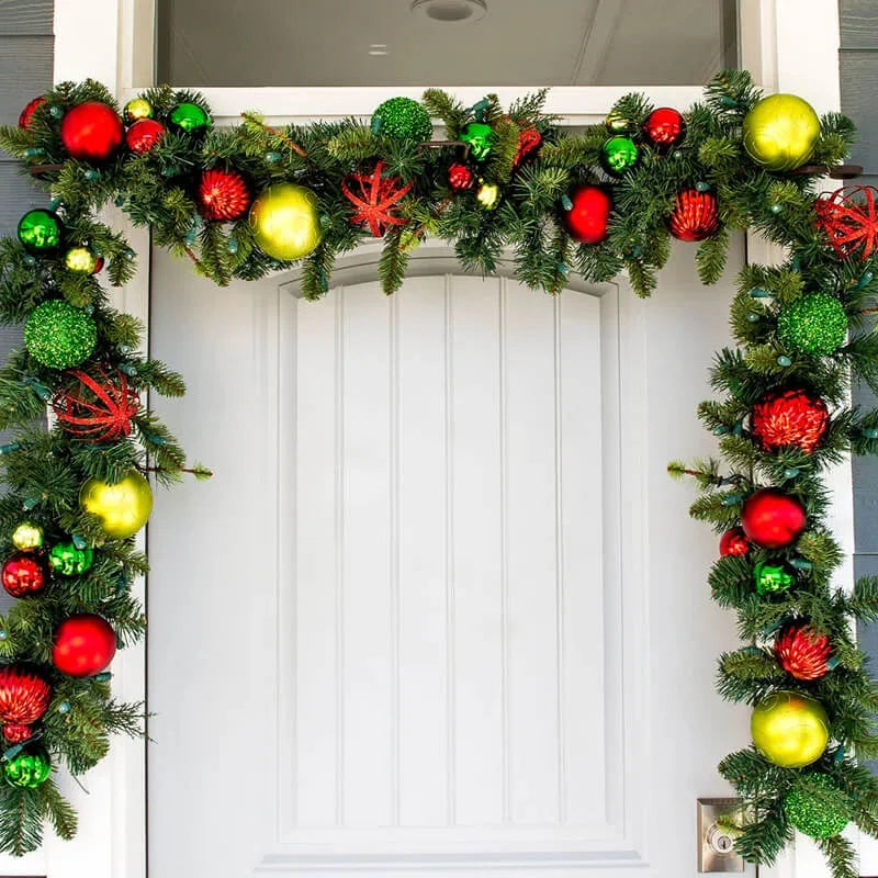Christmas garland with colorful ornaments on a white door